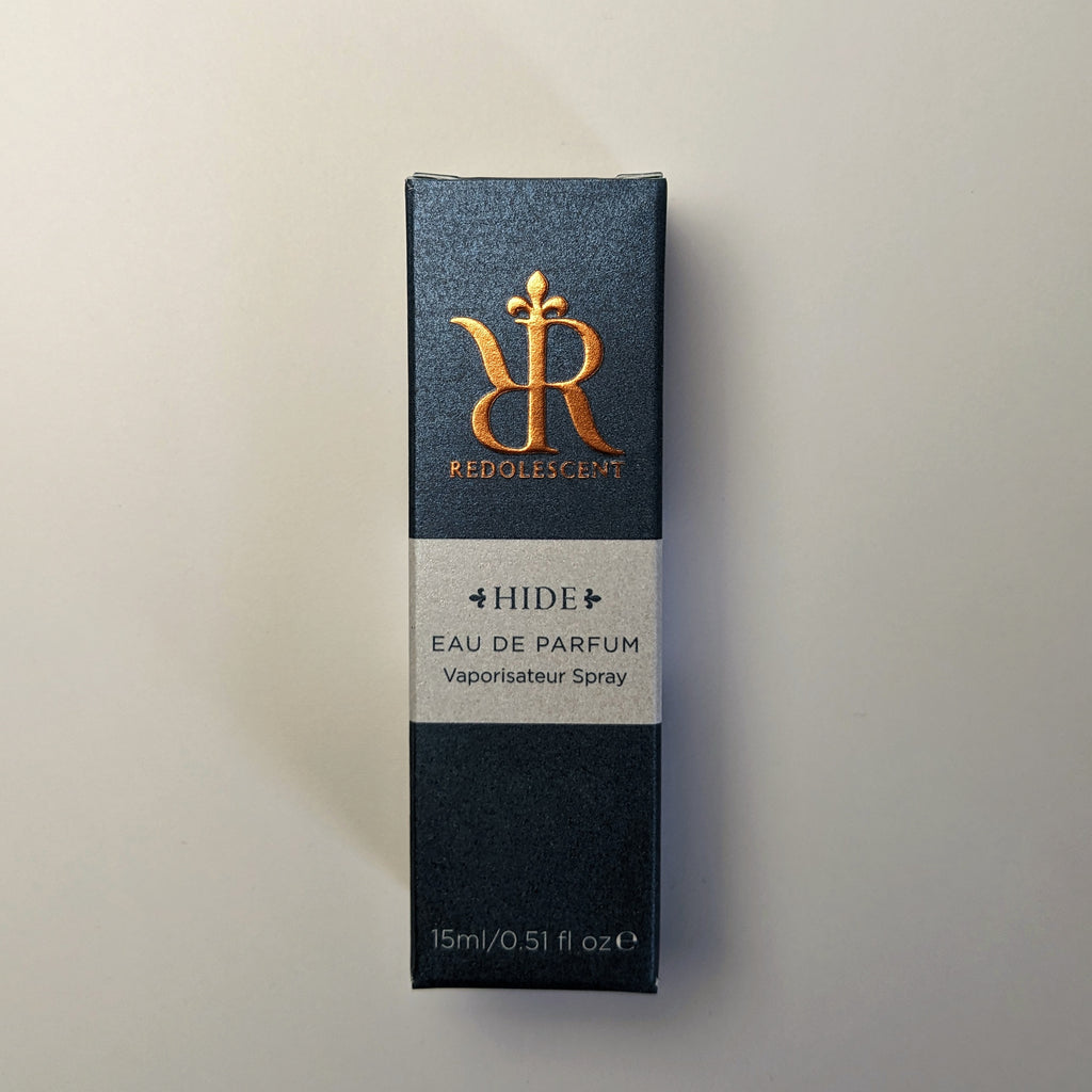 15ml travel niche perfume packaging for Hide. Dark blue box with embossed Redolescent logo, light blue band with Hide wording.