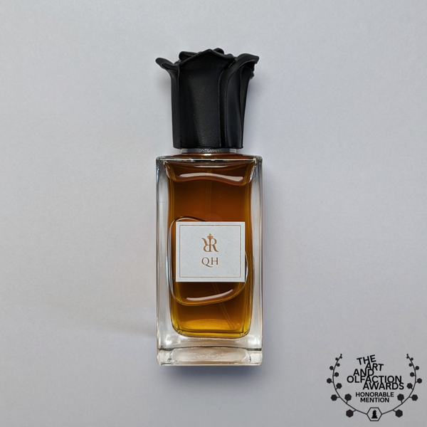 50 ml bottle of QH, a niche perfume by Redolescent. The liquid in the bottle is a rich amber colour. The cap of the bottle is the side profile of a rose with sharpened petals.